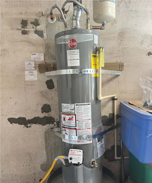 A clean and tidy residential garage space showing a completed water heater replacement and installation by an expert plumber.